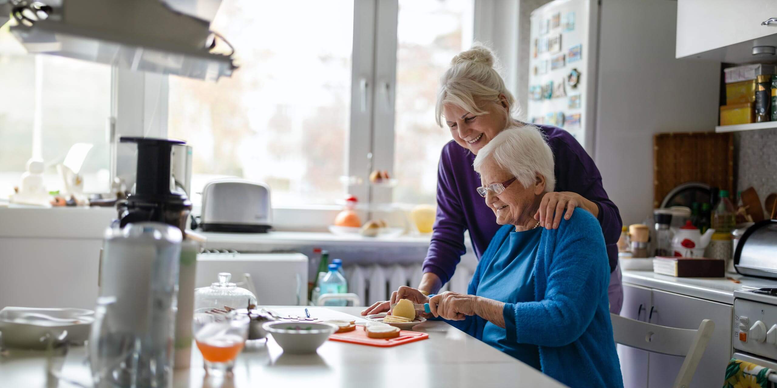 Zwei vertraute ältere Frauen zufrieden bei der Küchenarbeit
